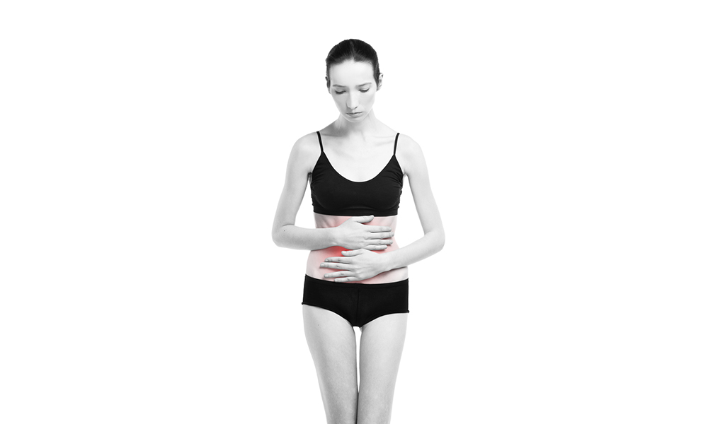 Woman with abdominal pain. Pain in the human body isolated on white background. Black and white photo with red dot